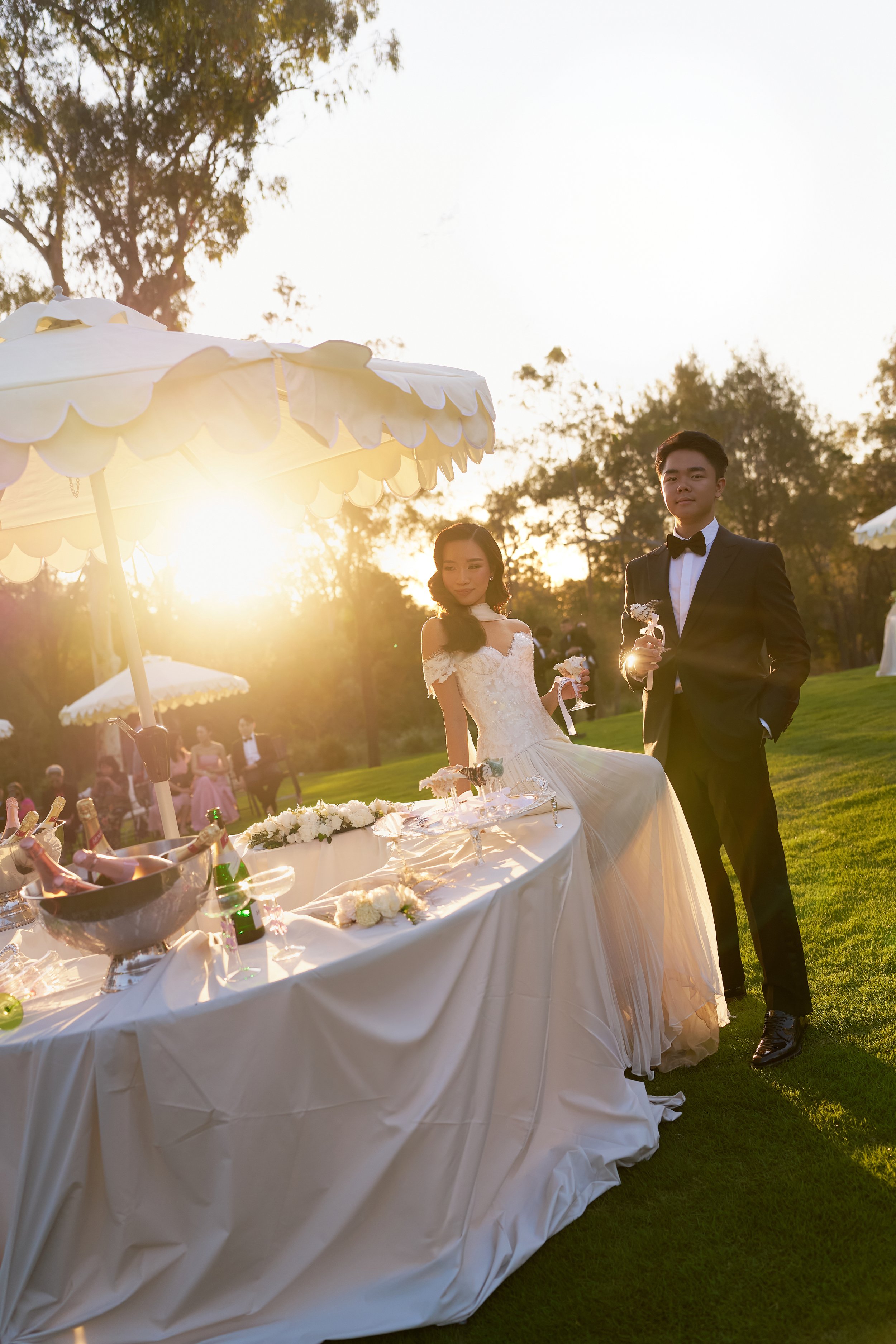 Bride and groom under French Wave umbrellas at golden hour — Rumi Hires wedding styling